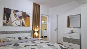 a bedroom with a bed and a painting on the wall at Emi Center Apartments in Gevgelija