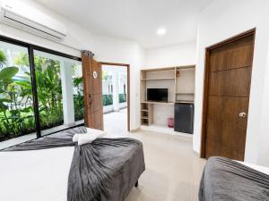 a bedroom with two beds and a large window at Wide Mouth Frog Quepos in Manuel Antonio