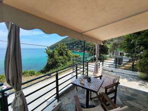 a balcony with a table and a view of the ocean at Kamari Guesthouse in Keramídhion