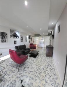 a living room with a couch and a red chair at Malecon Premium Rooms & Hotel in Santo Domingo