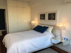 リスボンにあるPrincipe Real Luxe Flatのベッドルーム(青い枕の大きな白いベッド付)