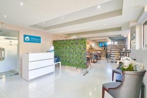 a waiting room with a green wall and chairs at Malecon Premium Rooms & Hotel in Santo Domingo