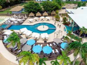an aerial view of a resort pool with umbrellas and chairs at Appartement avec piscine et accès direct plage 102 in Folle Anse
