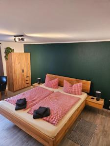 a bedroom with a large bed with pink pillows at Übernachten im Café Restaurant Vedder in Herscheid