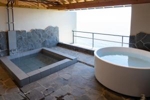 a bath tub in a bathroom with a view of the ocean at 河津Blue Ocean in Kawazu