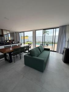 a living room with a green couch and a table at Condomínio Bosque da Praia, casa 193 Jacumã RN in Jacumã