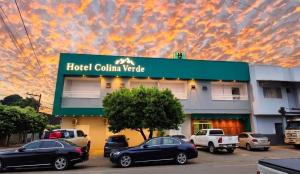 a hotel colina vista with cars parked in front of it at Hotel Colina Verde in Lucas do Rio Verde