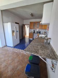 a kitchen with a counter top and a refrigerator at Casa marreiros in Aljezur
