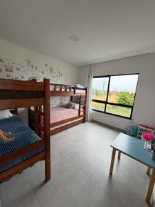 a bedroom with two bunk beds and a window at Condomínio Bosque da Praia, casa 193 Jacumã RN in Jacumã +21 photos