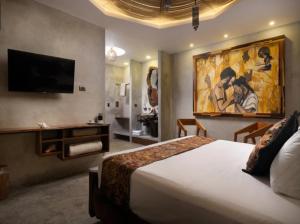 a hotel room with a bed and a painting on the wall at HOTEL ZAZIL KIN TULUM serenity & wellness in Tulum