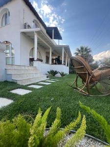 a bench sitting in the grass in front of a house at Oran House in Ayvalık