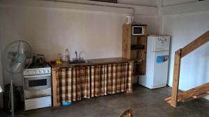 La cuisine est équipée d'un évier, d'une cuisinière et d'un réfrigérateur. dans l'établissement Casita Vaqueros, à Vaqueros