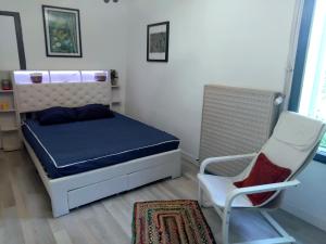 a small bedroom with a bed and a chair at Les Pipistrelles in Bagard