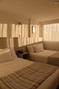 a hotel room with two beds and a window at Hotel San Francisco in Ubaté +46 photos