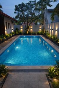a swimming pool in a backyard at night at Cinnamon Bungalow in Negombo