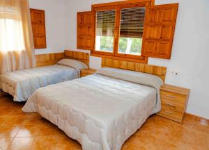 two beds in a room with wooden cabinets at Cortijo Cristea in Cehegín +62 photos