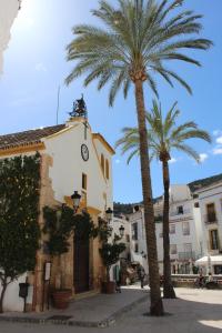 a clock on the top of a building with palm trees at Casa Cazorla in Ojén