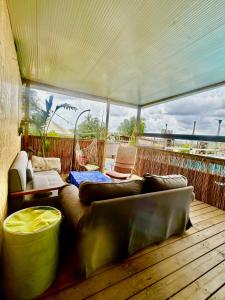 a living room with a couch and chairs on a deck at Tzimmer B'Kfar הצימר בכפר in Kefar Pines