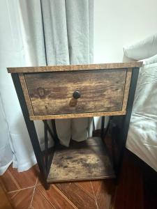 a wooden nightstand with a drawer next to a bed at Hotel boutique Blanca Gazza in Arica