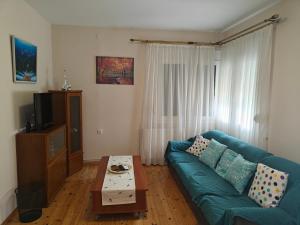 a living room with a blue couch and a coffee table at Harys Home in Korinos
