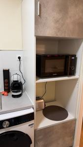 a small kitchen with a microwave and a stove at Studio Moderne - Proche 15mn Orly et 25mn Paris in Juvisy-sur-Orge +10 photos