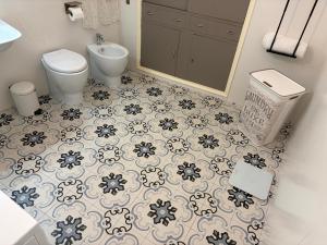 a bathroom with a toilet and a sink with a tile floor at Elisir house in Palermo +34 photos