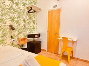 a bedroom with a bed and a yellow chair at Nanit Rooms Ibiza Hostal in Santa Eularia des Riu +21 photos