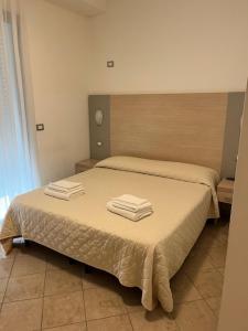 a bedroom with a bed with two towels on it at Hotel Etoile in Rimini