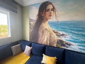 a painting of a woman sitting on top of a couch at perfect 2 bedrooms 2 balconies pool and golf in Asilah