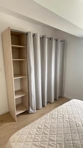 a bedroom with white curtains and a bed at Cosy Appartement avec Parking in Feugarolles