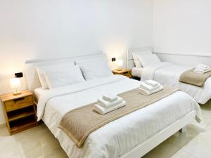 two twin beds in a room with two lamps at Corso 42 in Novara