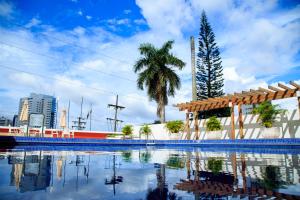 vistas a una piscina con palmeras y edificios en Da Vinci Hotel & Conventions by Easy Hotéis, en Manaus