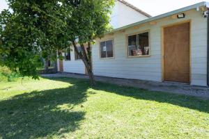 a house with a tree in front of a yard at Hostal Urenda in Los Ángeles