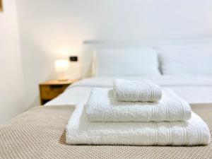 two towels are stacked on top of a bed at Corso 42 in Novara +17 photos