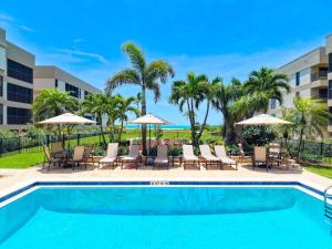 a swimming pool with chairs and umbrellas at Kings Crown 309 in Sanibel