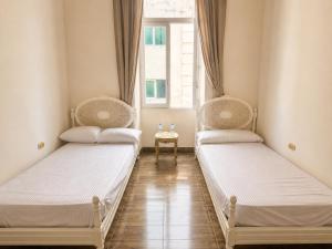 two beds in a room with a window at 7 Heaven in Alexandria +24 photos