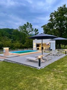 a group of chairs and umbrellas next to a pool at Mali Raj in Banja