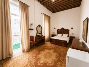 a bedroom with a bed and a desk and a window at 7 Heaven in Alexandria