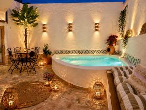 a large bath tub in a room with a table at Al Zahra Suites in Zahara de la Sierra