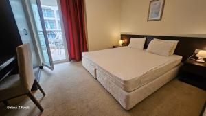 a bedroom with a large bed with a red curtain at Красавиците тъмнокоси Sunset Family in Pomorie