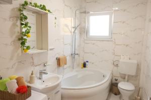 a white bathroom with a sink and a toilet at Apartman Boki in Bileća +16 photos