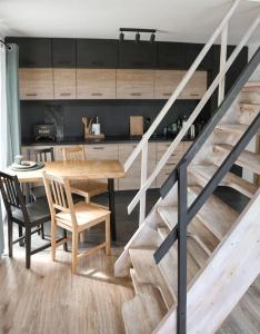 a kitchen and dining room with a wooden table and stairs at Eleonor Accommodation exclusive house in Liszki