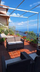 a patio with couches and plants on a balcony at La casa del sole in Conca dei Marini