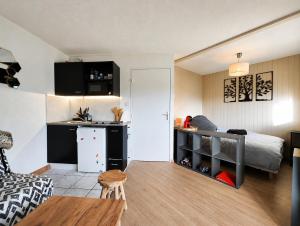 a small apartment with a bed and a kitchen and a room at Le refuge des sportifs - studio cosy jardin - wifi in Mijoux +9 photos