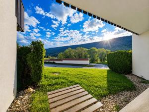 a backyard with a bench and a view of a mountain at Le refuge des sportifs - studio cosy jardin - wifi in Mijoux