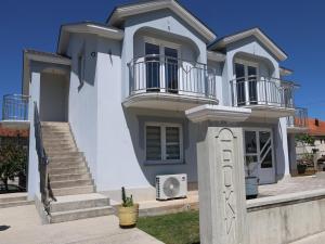 a white house with stairs and balconies on it at Apartman Boki in Bileća