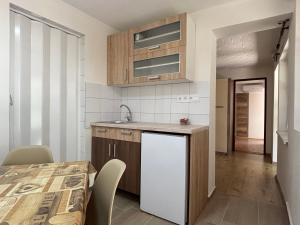 a kitchen and dining room with a table and a refrigerator at Prázdninový dom in Štúrovo +22 photos