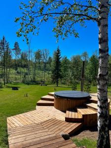 a wooden deck with a table in a park at ARKA Puhkemajad in Päidre