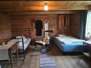 ein Schlafzimmer mit zwei Betten und einem Stuhl in einer Hütte in der Unterkunft Gamlastova in Samlanes