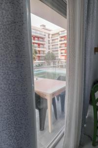 a room with a table and a swimming pool seen through a window at Anchor Apartments in Shëngjin